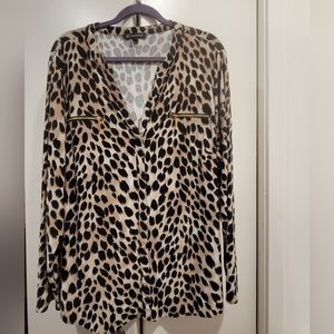 Ladies tunic blouse with decorative zipper pockets in front. 95% poly 5% spandex